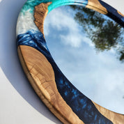 Ocean-inspired epoxy and olive wood wall art mirror by Artdesigna featuring a unique wooden frame and glossy epoxy ocean design.